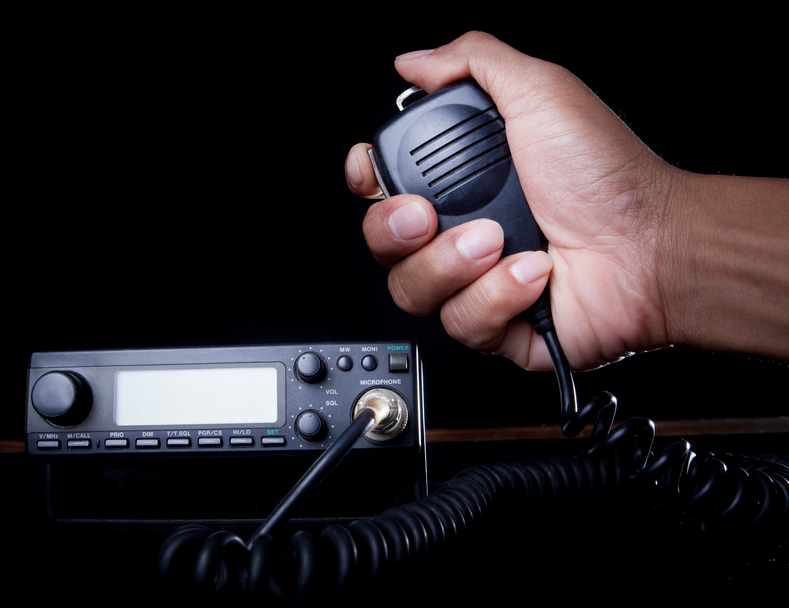 hand of Amateur radio holding speaker and press for radio communication theme ABL Circuits