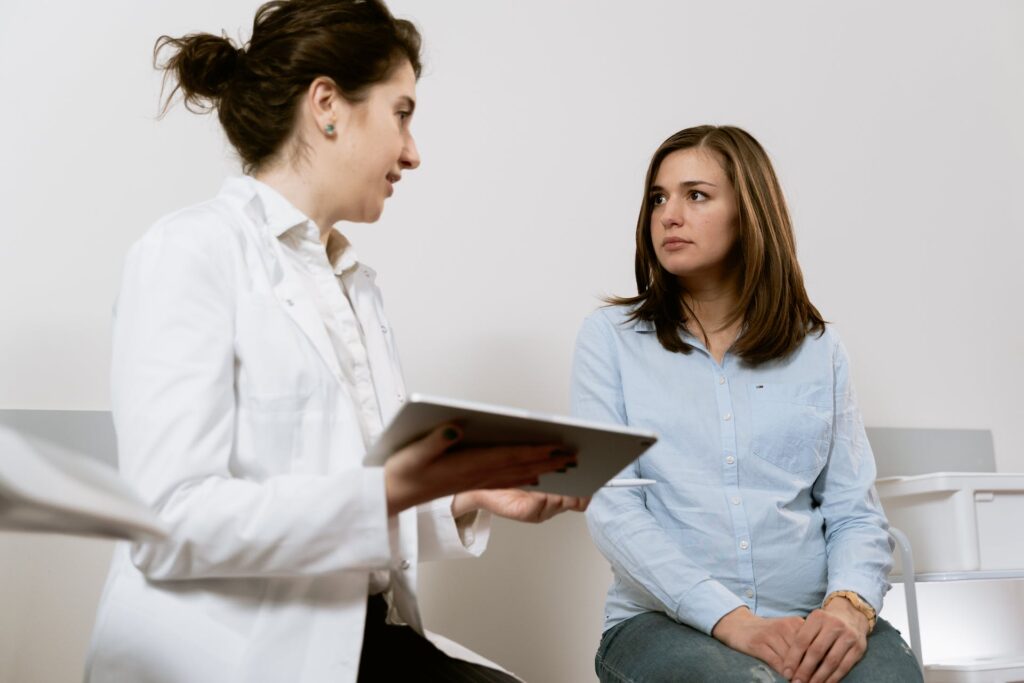 A doctor holding an internet connected tablet with a patient